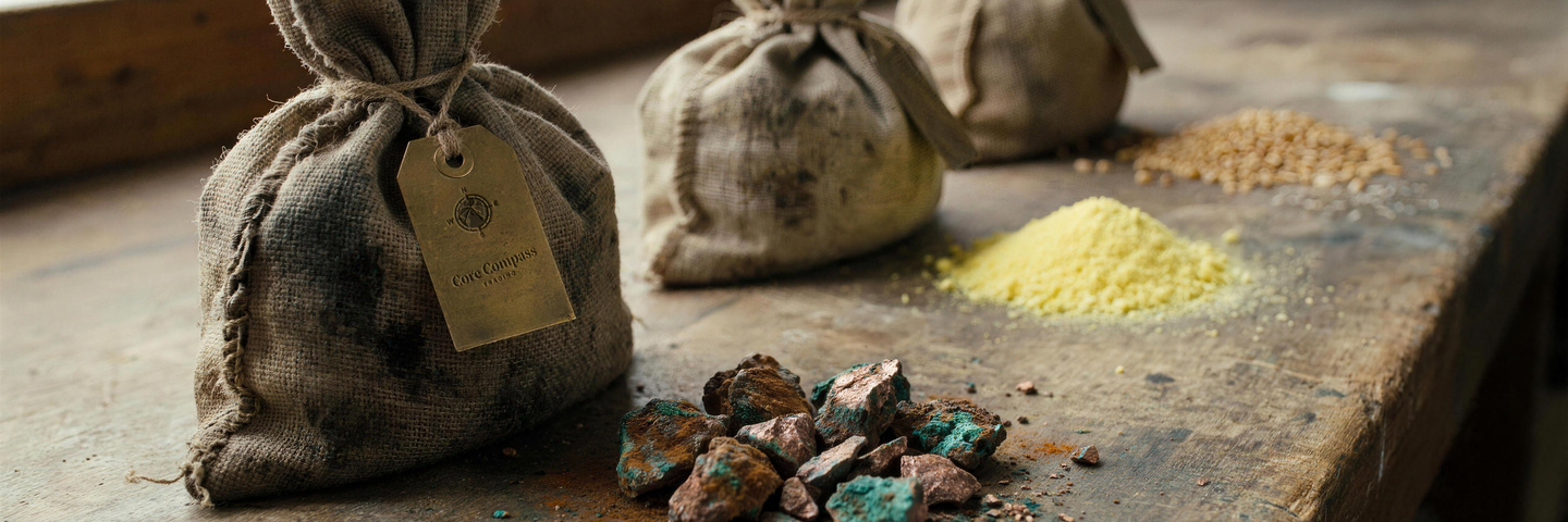 Sample sacks with the firm’s tag on a workbench, ore and grain beside them